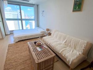 a living room with a couch and a bed and a table at House of Hyuni in Busan