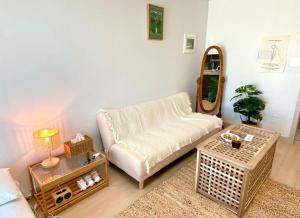 a living room with a white couch and a mirror at House of Hyuni in Busan