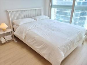 a white bed in a bedroom with a window at House of Hyuni in Busan