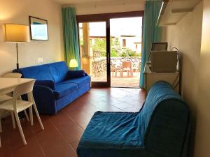a living room with a blue couch and a table at Residence Bouganville in Porto Rotondo
