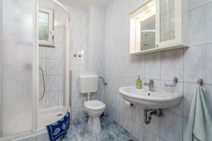 a white bathroom with a toilet and a sink at Apartments Cathy in Mandre +86 photos