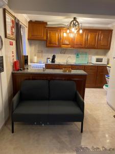 a black couch in a kitchen with a counter at A Casa da Rapariga de Cabelo Azul in Manteigas