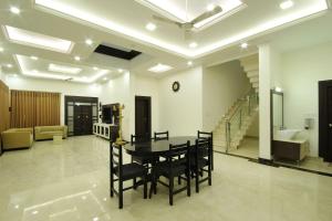a dining room with a table and chairs in a room at solomons ark luxury pool villa in Cochin