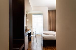 a room with a bed and a table and a chair at Astoria Resort in Riva del Garda