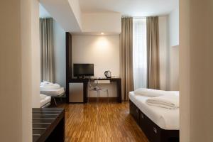 a hotel room with a bed and a television at Astoria Resort in Riva del Garda