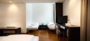 a hotel room with a bed and a tv and chairs at Astoria Resort in Riva del Garda