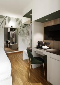 a bedroom with a bed and a desk with a chair at Astoria Resort in Riva del Garda