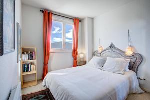 una camera con letto e finestra con tende arancioni di Can Francisco - Maison vue montagne a Les Angles