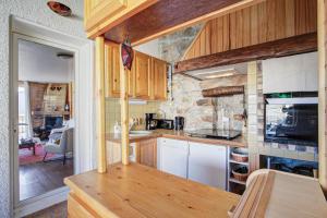 una cucina con mobili in legno e un muro in pietra di Can Francisco - Maison vue montagne a Les Angles Altre 16 foto