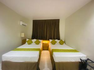 Rúm í herbergi á Maxi Hotel and Event Center