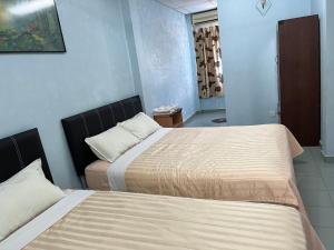 a bedroom with two beds in a room at Lenggong - Soon Lee Hotel in Kampong Ulu Jepai