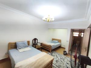 a bedroom with two beds and a chandelier at Where landsacpe view meets Luxury in Cairo