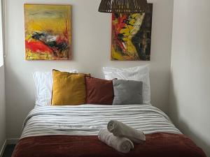 a bed with two paintings on the wall at La Lone 1870 in La Roche-de-Glun