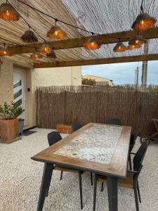 a table and chairs on a patio with lights at LE TERRACOTTA COTE D'AZUR - Proche PLAGE - Terrasse & Confort - CLIM - Parking et Wifi Gratuit- OFFRE SPECIALE in Fréjus