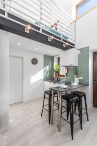 a kitchen with a table and stools in a room at Chic Loft with Garden, Sleeps 4 in Porto