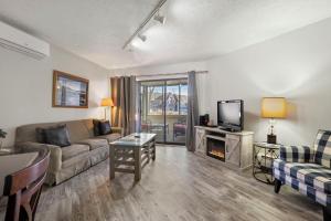 a living room with a couch and a tv at 105 Pointes North Inn in Charlevoix