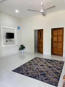 a living room with a ceiling fan and a rug at inap desa batu buruk 2 in Kuala Terengganu