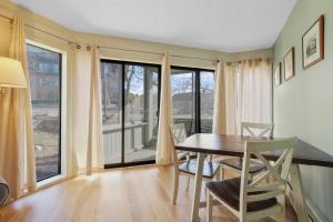 a dining room with a table and chairs and windows at 110 Pointes North Inn in Charlevoix