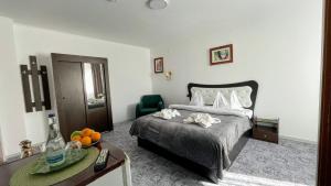 a bedroom with a bed and a table and a chair at Pensiunea-restaurant Casa Țărănească Bușteni in Buşteni