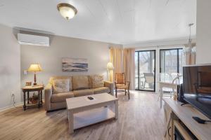 a living room with a couch and a tv at 107 Pointes North Inn in Charlevoix