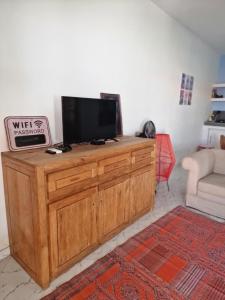 a television on a wooden cabinet in a living room at appartement cosy in Somone