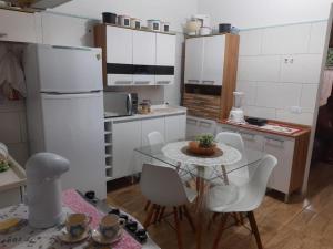 a kitchen with a table and a white refrigerator at Cantinho do sossego in Paraty