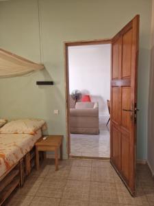 a bedroom with a bed and a door and a couch at appartement cosy in Somone +19 photos