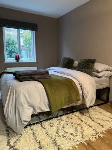 a large bed in a bedroom with a window at W9 Gem Stylish 2 Bed Flat in London