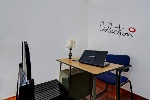 a desk with a laptop and a blue chair at Hotel O Valley View Residency in Vagamon