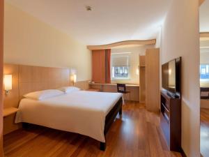 a bedroom with a large white bed and a desk at ibis Stuttgart Airport Messe in Leinfelden-Echterdingen