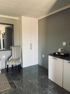 Una habitación con una cocina con una silla y un mostrador. en Mercy House Lodge, en Northam
