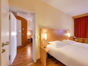 a bedroom with a large white bed and a red window at ibis Stuttgart Airport Messe in Leinfelden-Echterdingen