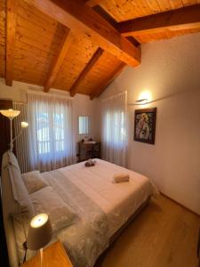 a bedroom with a large bed in a room with wooden ceilings at La Maison Vieille in Saint Vincent +25 photos