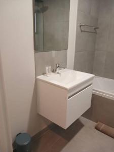 a white bathroom with a sink and a tub at 302 Mossel Cove Sea View Deluxe in Mossel Bay