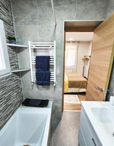 a bathroom with a tub and a sink and a bed at Casa El Mirador in Trijueque