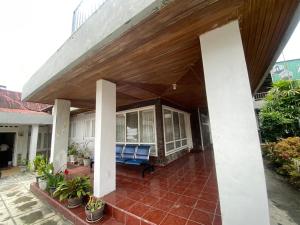 a porch of a house with a wooden roof at Nankanduang Homestay in Bukittinggi