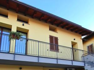 a yellow building with a balcony with plants on it at Elements Orio - Rooms & Apartments in Orio al Serio