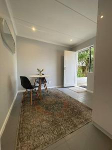 a dining room with a table and a rug at Whale Watches Seaside Retreat in Hermanus