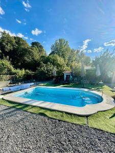 a large swimming pool in a yard with a house at Cortijo Luz de la Sierra in Dúdar