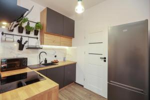a kitchen with a stainless steel refrigerator and wooden counters at Apartament Blues, ul Jastrzębia in Lublin +12 photos
