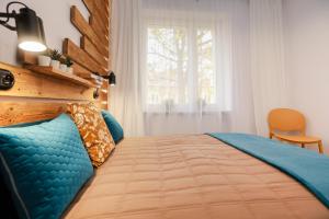 a bedroom with a bed with a blue comforter and a window at Apartament Blues, ul Jastrzębia in Lublin