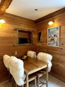ein Esszimmer mit einem Tisch und weißen Stühlen in der Unterkunft 2 pièces Suzie in Saint-Étienne-de-Tinée