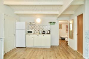 a kitchen with white cabinets and a white refrigerator at פרדייז ריזורט in Had Nes