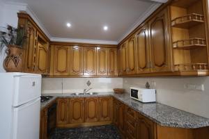 a kitchen with wooden cabinets and a white microwave at Antonia Medina Relax in Cogollos de Guadix +16 photos