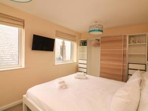 um quarto com uma cama branca e uma tv em Full Deck em Dartmouth mais 16 fotografias