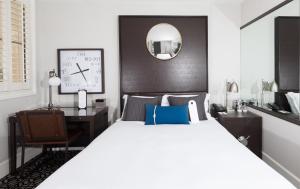 a bedroom with a bed and a desk and a clock at Harbor Court Hotel in San Francisco +34 photos