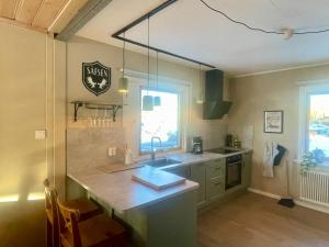 a kitchen with a sink and a counter with a window at Fredriksberg Säfsen in Fredriksberg