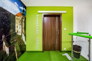 une chambre verte avec une porte et un panneau sur le mur dans l'établissement Przystań Leśniów, à Żarki