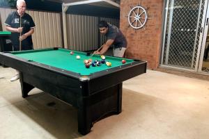 a man playing a game of pool in a room at Cheerful 3 Bedroom House With Free Parking in Kingswood