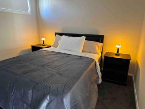 a bedroom with a large bed with two night stands at Granny Guest House Sydney Blue Mountain in Kingswood